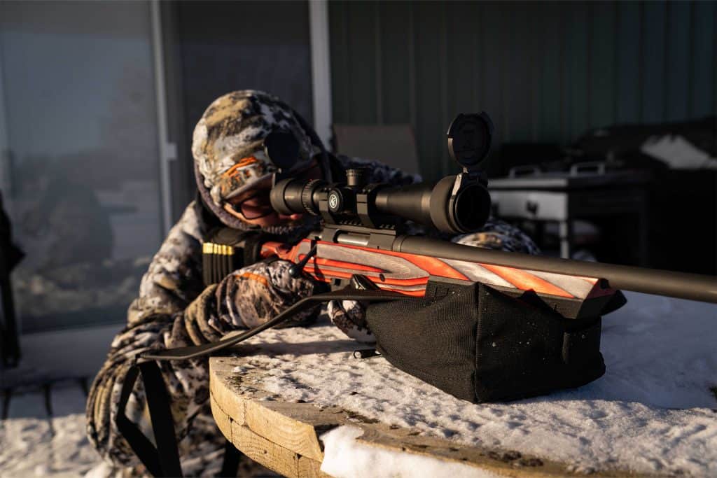 Shooter using a Sticky Holsters shooting rest bag for rifle stability.