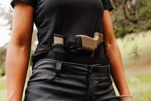 A woman standing outdoors with a Sticky Holster and Mag Carrier
