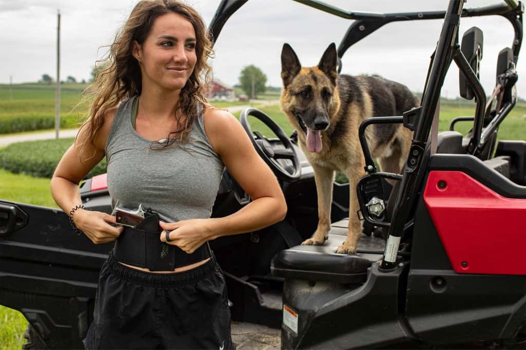 Woman wearing a Sticky Holsters Belly Band for concealed carry outdoors.