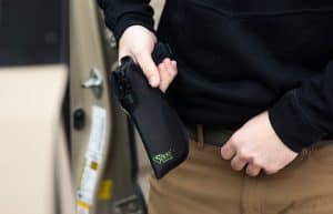 Person holding a handgun in a Sticky Holster for IWB carry.