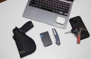 Top-down view of a Sticky Holster EDC setup with handgun and personal accessories.